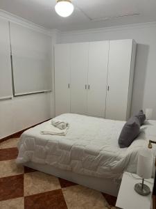 Schlafzimmer mit einem großen Bett und weißen Schränken in der Unterkunft El Torreón 3 in Lora del Río