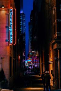a person walking down a city street at night at Hotel Indigo Nashville - The Countrypolitan in Nashville