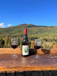 two glasses of red wine sitting on a wooden table at Stay at Rivermist Dahlonega in Dahlonega