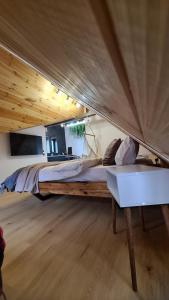 ein großes Bett in einem Zimmer mit Holzdecke in der Unterkunft Casa Chiper - Attic apartment with view in Braşov