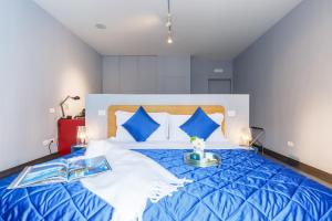 uma grande cama azul e branca num quarto em Dimora Doria d'Angri em Nápoles