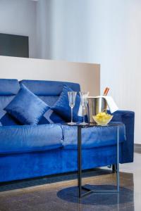 um sofá azul com uma mesa com óculos em Dimora Doria d'Angri em Nápoles