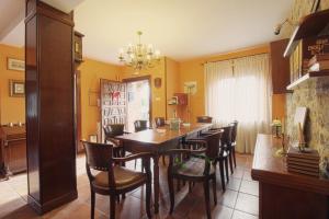 Casa Pinna في سانتيانا ديل مار: غرفة طعام مع طاولة وكراسي خشبية
