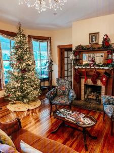 a living room with a christmas tree and a fireplace at Sweetwater Branch Inn in Gainesville