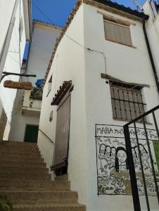 ein weißes Gebäude mit Treppen und einem Schild darauf in der Unterkunft Casa Harillo-Charming 1 bedroom in Genal mountains in Genalguacil