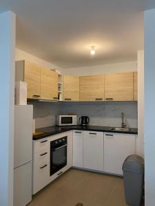 a kitchen with white appliances and wooden cabinets at Monaco Grand Prix Nouveau in Beausoleil