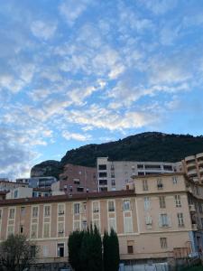 a large building with a mountain in the background at Monaco Grand Prix Nouveau in Beausoleil