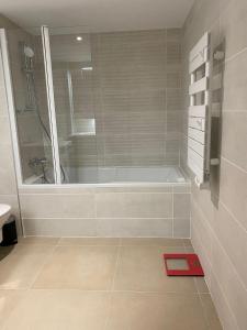 een badkamer met een bad en een rode weegschaal op de vloer bij Monaco Grand Prix Nouveau in Beausoleil