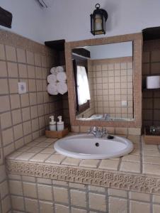 Casa Harillo-Charming 1 bedroom in Genal mountains في خينالغواثيل: حمام مع حوض ومرآة