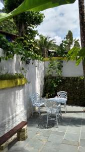 a patio with two chairs and a table at Casas de 1, 2 e 4 quartos-100m da praia- com AC-WIFI-Estac in Camburi