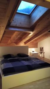 Schlafzimmer mit einem großen Bett und einem Dachfenster in der Unterkunft Apartment Hohenwerfen in Werfen