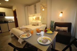 une chambre d'hôtel avec une table et de la nourriture dans l'établissement Casa Boytac by CosyCasa Praia Peniche, à Peniche
