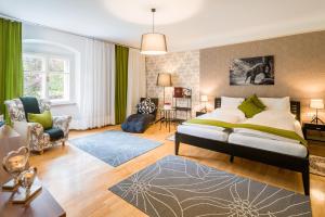 a bedroom with a large bed and a living room at Schlosshotel Rosenau Superior in Schloss Rosenau