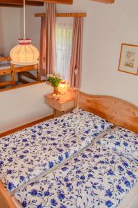 a bedroom with a bed with a blue and white comforter at Apartment Sigrid in Arriach