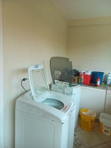 a white washing machine with a laptop on top of it at Casa pé na areia (50 mestros da praia) in Peruíbe +15 photos