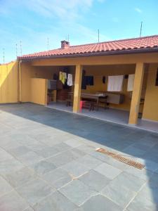 a house with a patio with a table and a roof at Casa pé na areia (50 mestros da praia) in Peruíbe