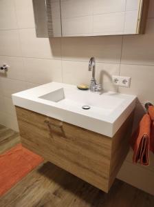 een badkamer met een witte wastafel en een spiegel bij Sonja´s Ferienwohnung in Patergassen