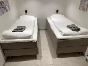 two beds sitting next to each other in a room at Plomben B in Båstad