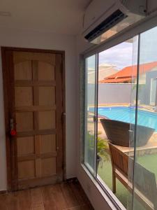 サクアレマにあるPousada Litorâneaのドア付きの客室で、プールの景色を望めます。