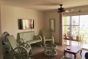 a living room with chairs and a table and a window at Nice Apt in punta cana 7 minutes from airport , 10 minutes from the beaches in Punta Cana