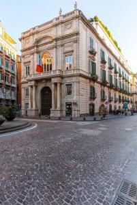 um grande edifício com uma bandeira sobre ele em uma rua em Dimora Doria d'Angri em Nápoles