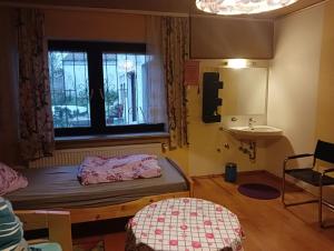 a room with a bed and a sink and a window at Ruhiges Keller Apartement NM in Neumarkt in der Oberpfalz