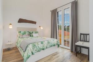 a bedroom with a bed and a balcony at Casa D`Avó Celina in Funchal