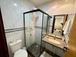 een badkamer met douche, toilet en wastafel bij BEIRA MAR 2 Quartos com Ar e Cozinha Completa in Maceió +22 foto's
