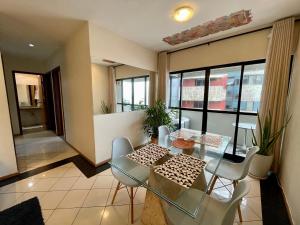 een eetkamer met een glazen tafel en stoelen bij BEIRA MAR 2 Quartos com Ar e Cozinha Completa in Maceió