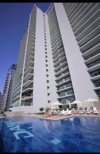 a large building with a swimming pool in front of it at New Luxury Modern Canal View. in Dubai