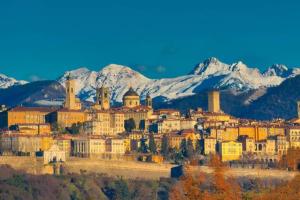 a city with snowy mountains in the background at [Elegant Apartment] in Bergamo Center in Bergamo