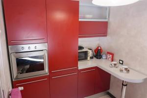 a small kitchen with red cabinets and a microwave at [Elegant Apartment] in Bergamo Center in Bergamo