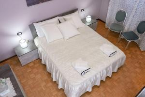 a bedroom with a large white bed with two chairs at [Elegant Apartment] in Bergamo Center in Bergamo