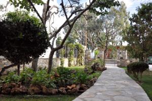 einen Gehweg in einem Garten mit Bäumen und Pflanzen in der Unterkunft Sea La Vie in Volos