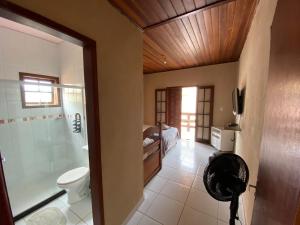 a bathroom with a toilet and a shower and a sink at Pousada do Foguete in Cabo Frio