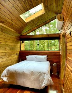 a bedroom with a bed in a room with a window at Pousada Alpes da Araucárias in São Francisco de Paula