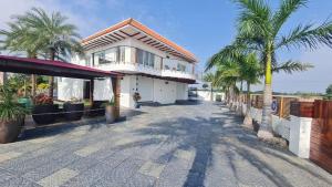 a large house with palm trees in front of it at 154 Pearl Beach in Mahabalipuram