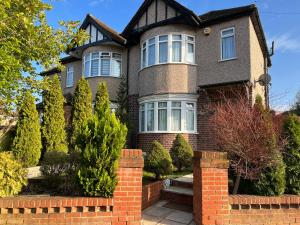 a house with a brick fence in front of it at TJ Homes - One double bed room with garden view - Next to tube station in Ruislip