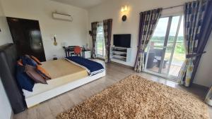 a bedroom with a bed and a television and a rug at 154 Pearl Beach in Mahabalipuram