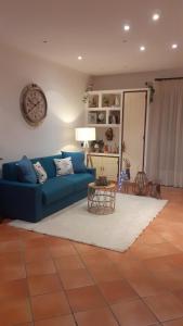 a living room with a blue couch and a table at Terrazza Miracapri in Pozzuoli