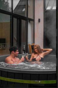 a man and a woman in a bath tub at Czarne Domki in Zwierzyniec