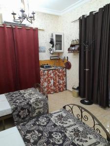 a room with red curtains and a kitchen with a table at mini house in Aqaba