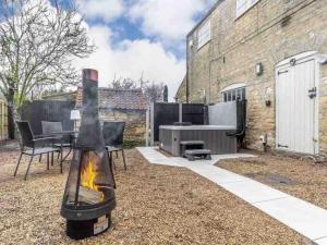 a backyard with a barbecue grill and a table at The Retreat-luxury cottage with hot tub (sleeps 4) 