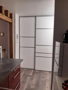 cocina con armarios blancos y nevera en Joli appartement T2 Agglo Troyes, en Sainte-Savine