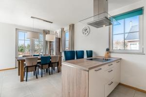 a kitchen and dining room with a table and blue chairs at Domek v Podještědí in Januv Dul