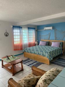 um quarto com uma cama, uma mesa e um sofá em Orrie's Beach Bar and Hotel em Crab Hill