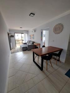 uma sala de estar com uma mesa e um sofá em Residence Portal do Santinho em Florianópolis