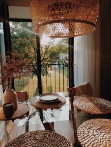 een eetkamer met een tafel en stoelen en een groot raam bij Breeze Albatross in Ķesterciems