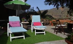 エルミグアにあるCasa Jonayの草の中に座るカラフルなクッションの椅子2脚