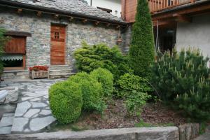un giardino di fronte a una casa con cespugli di B&B Lo Tatà a Fenis